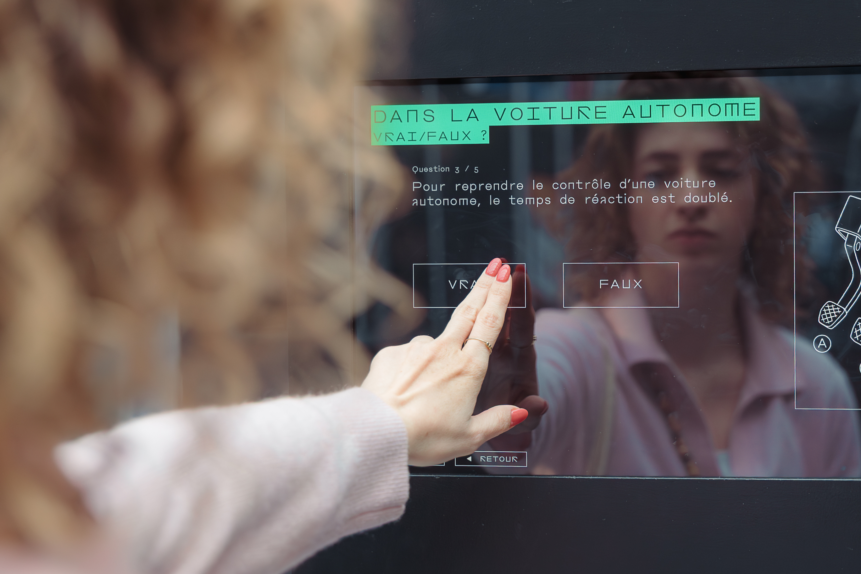 Visiteur sur la voiture autonome dans l'exposition Destination IA