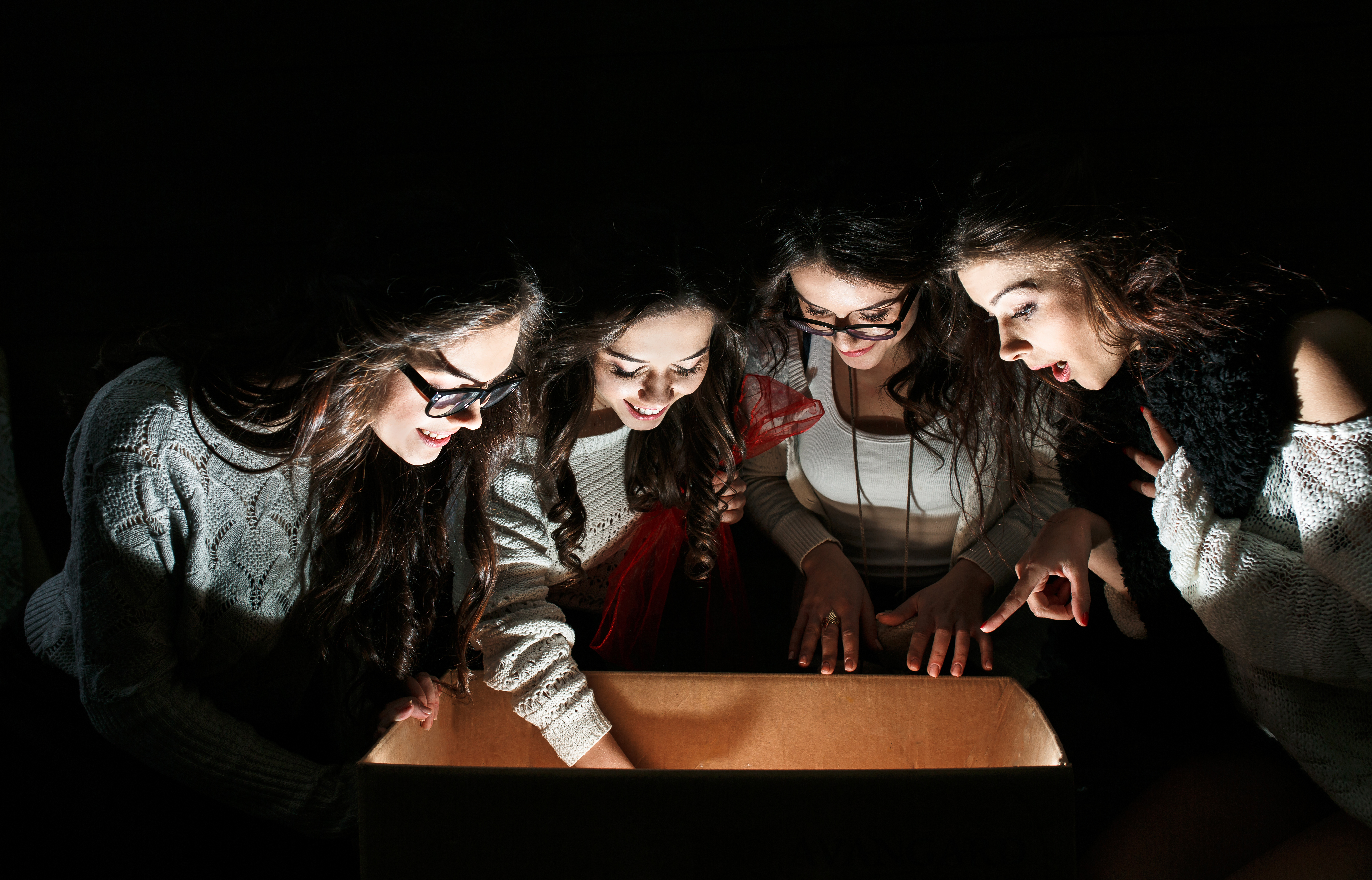 Sisters opens a box with a Christmas present and fascinated looks inside
